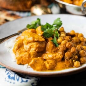 butter chicken with chickpea masala on white plate