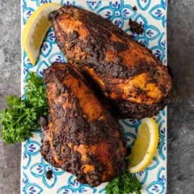two roasted chicken breasts on blue patterned plate