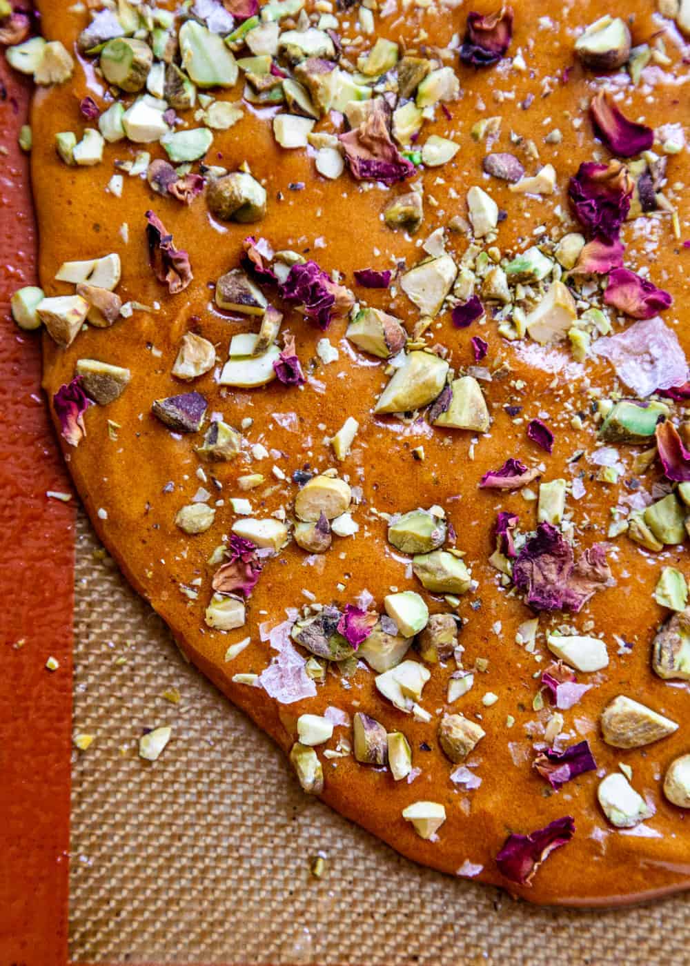 closeup image of a Persian dessert made with cooked sugar, pistachios, rose petals, and saffron
