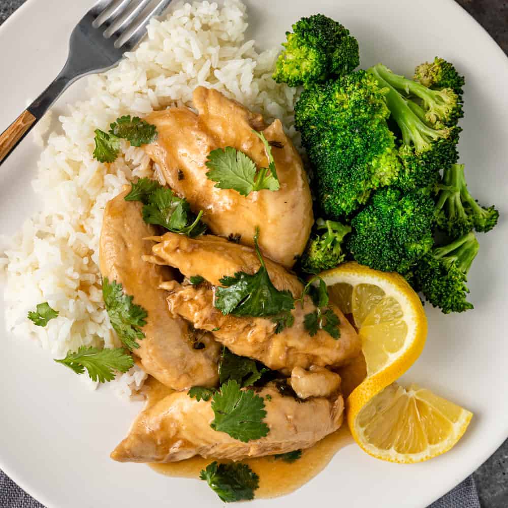 lemon ginger steamed chicken breast on white plate with rice and broccoli