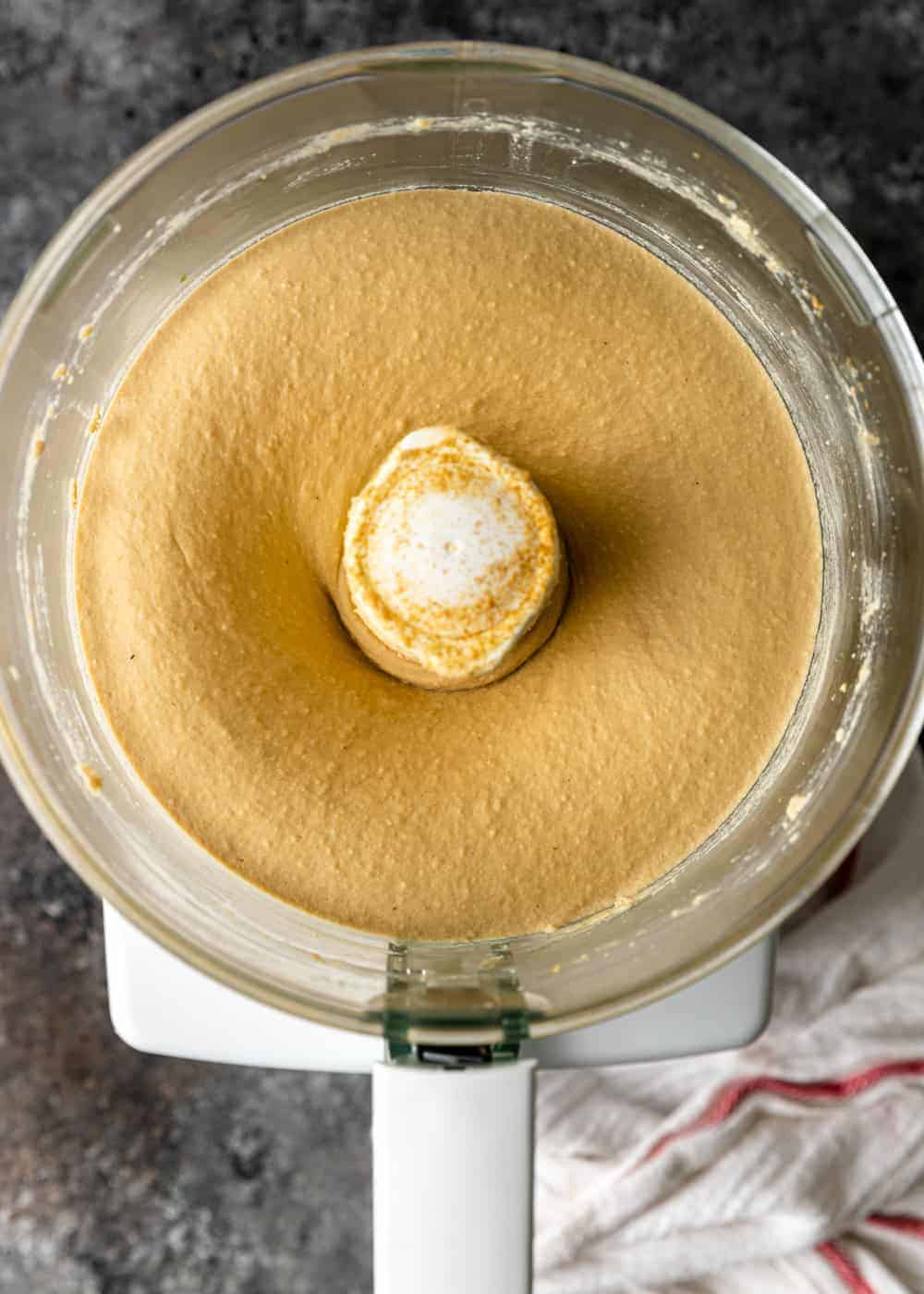 overhead: creamy hummus recipe in bowl of food processor