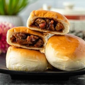 Chinese BBQ pork buns cut open and stacked on top of each other on plate