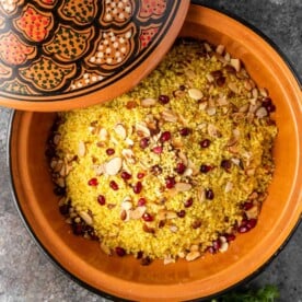couscous with pomegranate arils and almonds in a tagine with a decorative lid