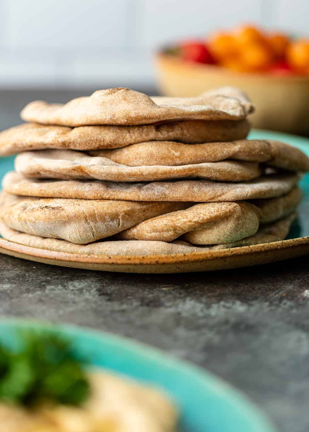 A stack of pita bread on a ceramic plate.