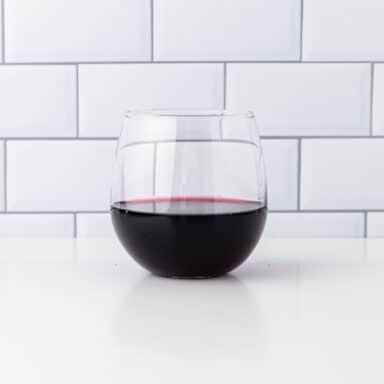 glass of dry red wine on white table top