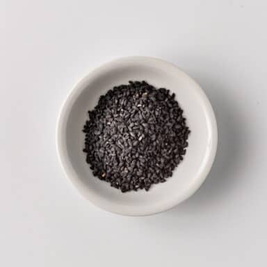 nigella seeds in small white bowl