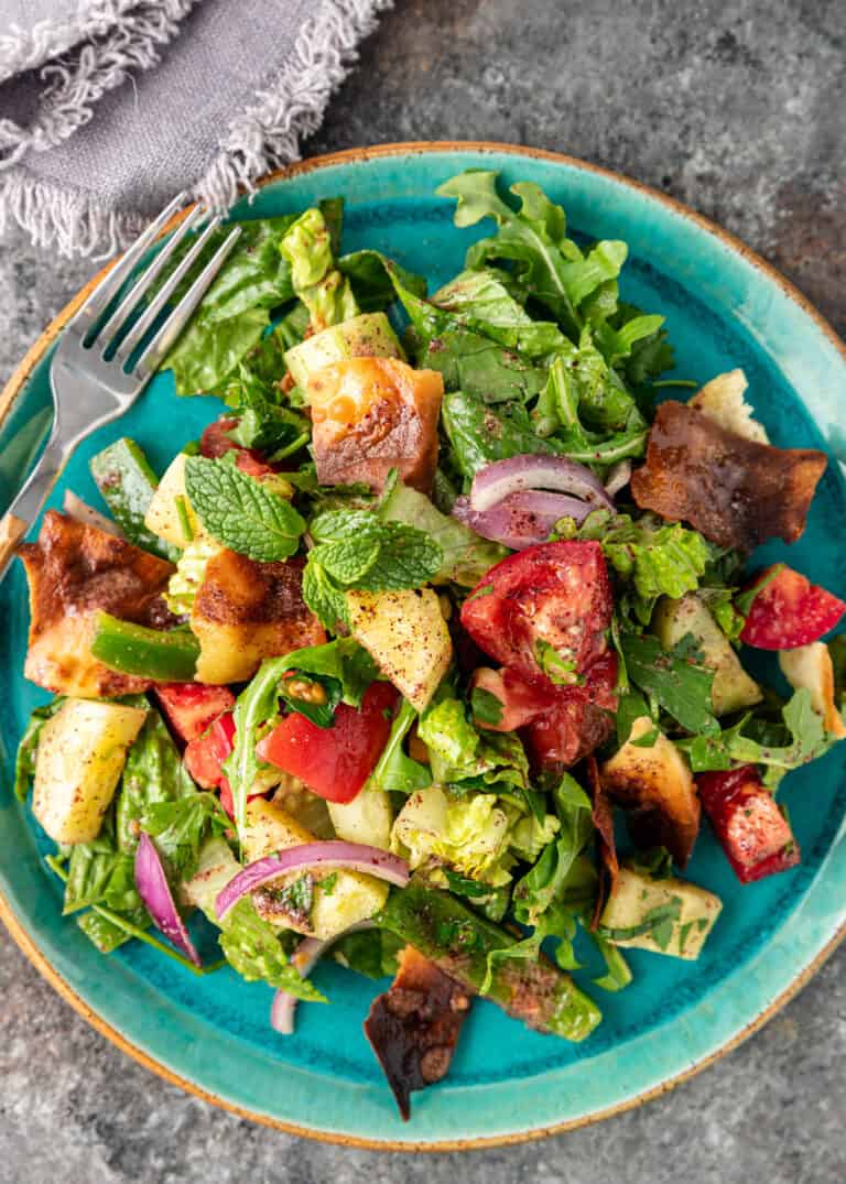 Lebanese Fattoush salad on a blue plate with a fork