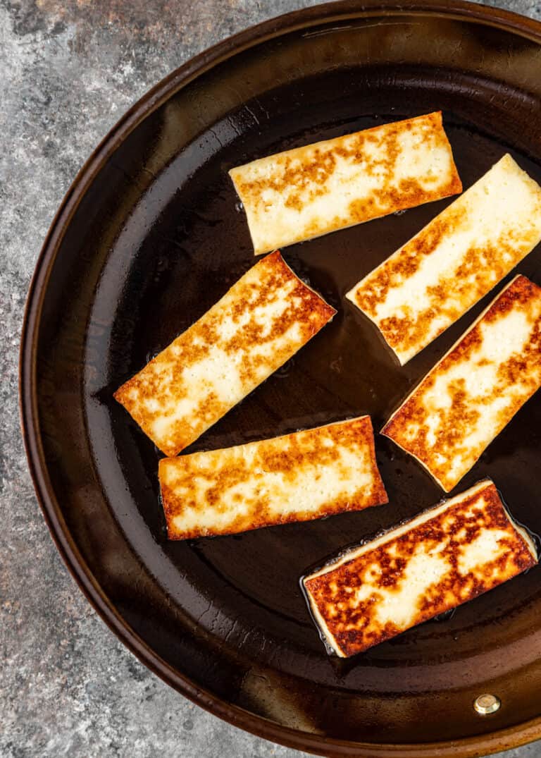 overhead: frying halloumi cheese in skillet