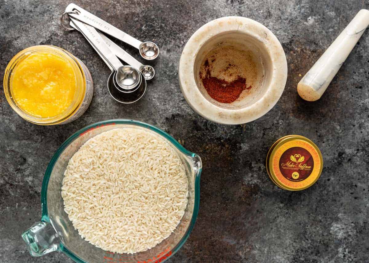 overhead image of ingredients and a mortar and pestle for making Persian rice tahdig recipe