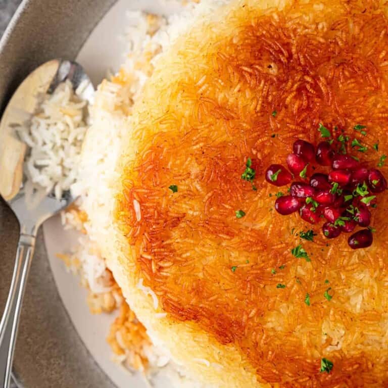 overhead image of serving spoon on plate of Persian crispy rice