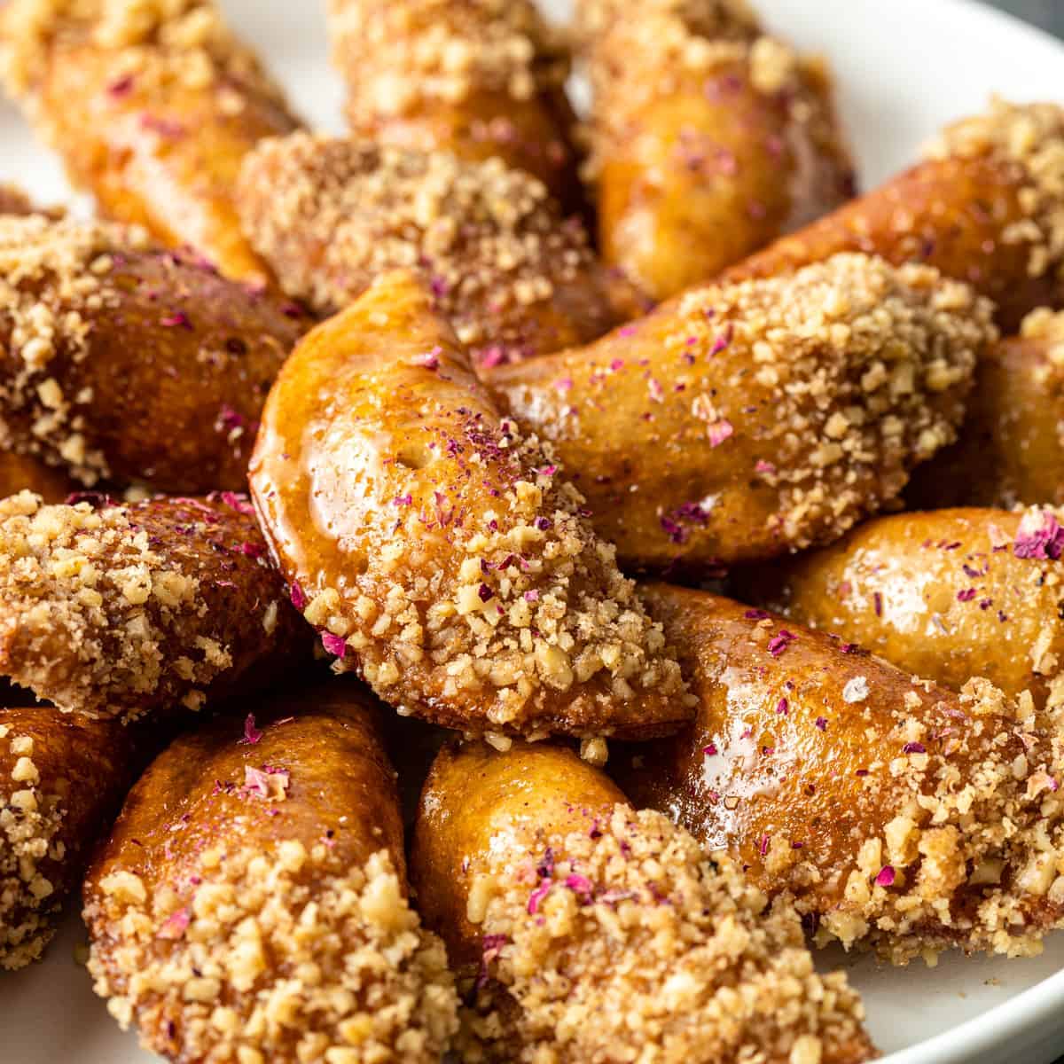 close up: fried Qatayef (stuffed pancakes) dipped in crushed walnuts