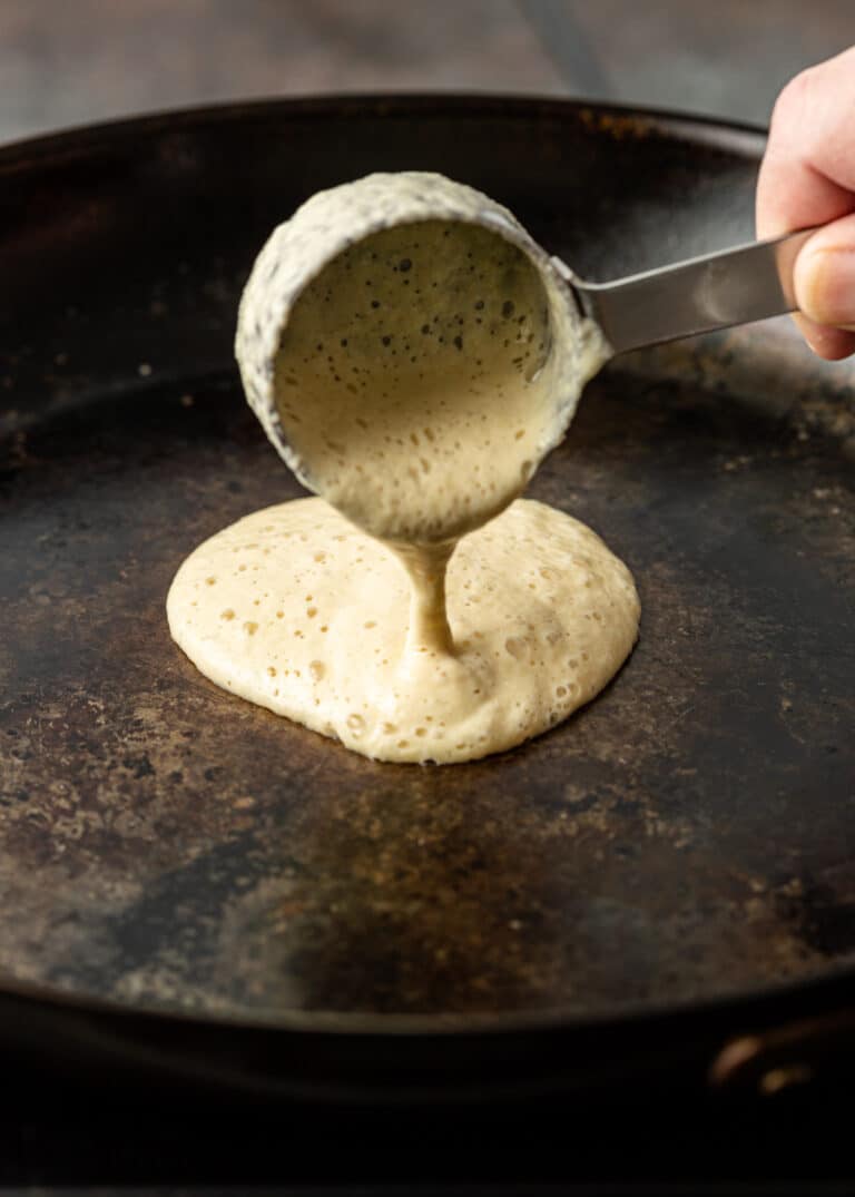 pouring Moroccan pancake batter into hot skillet