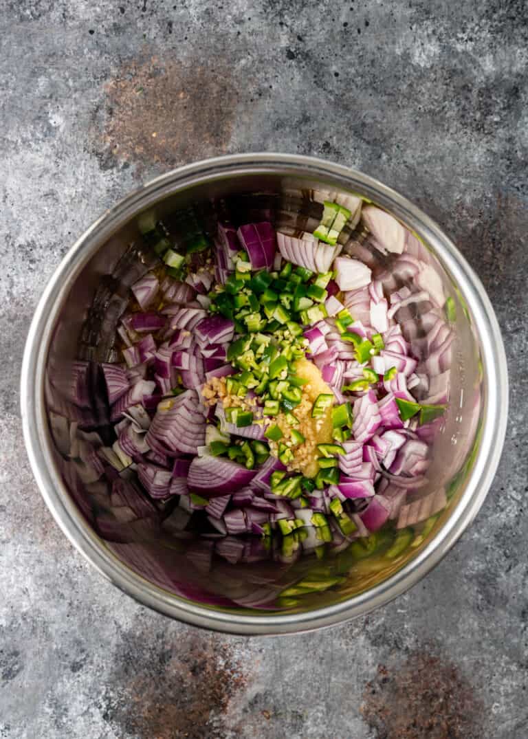 pot of chopped raw red onion, green chili peppers, garlic and seasonings