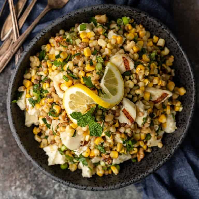 Grilled Halloumi, Corn, and Fregola Salad in large black serving bowl