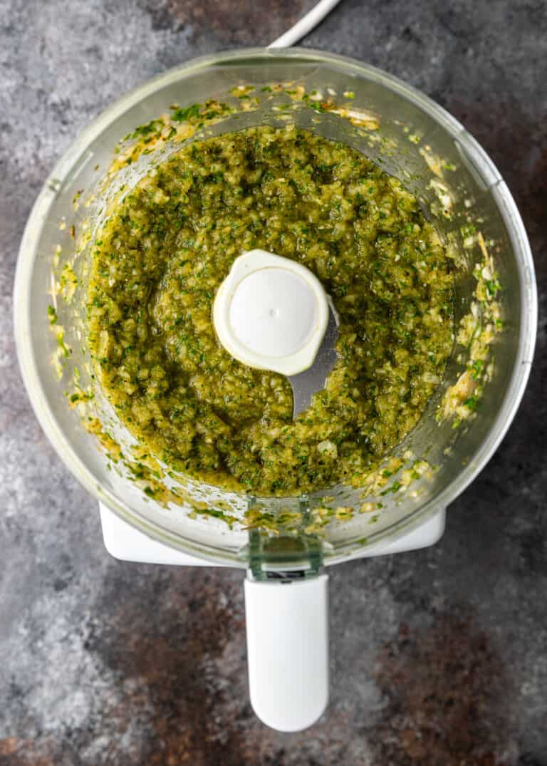 overhead: bowl of food processor with fresh herb hand pie filling