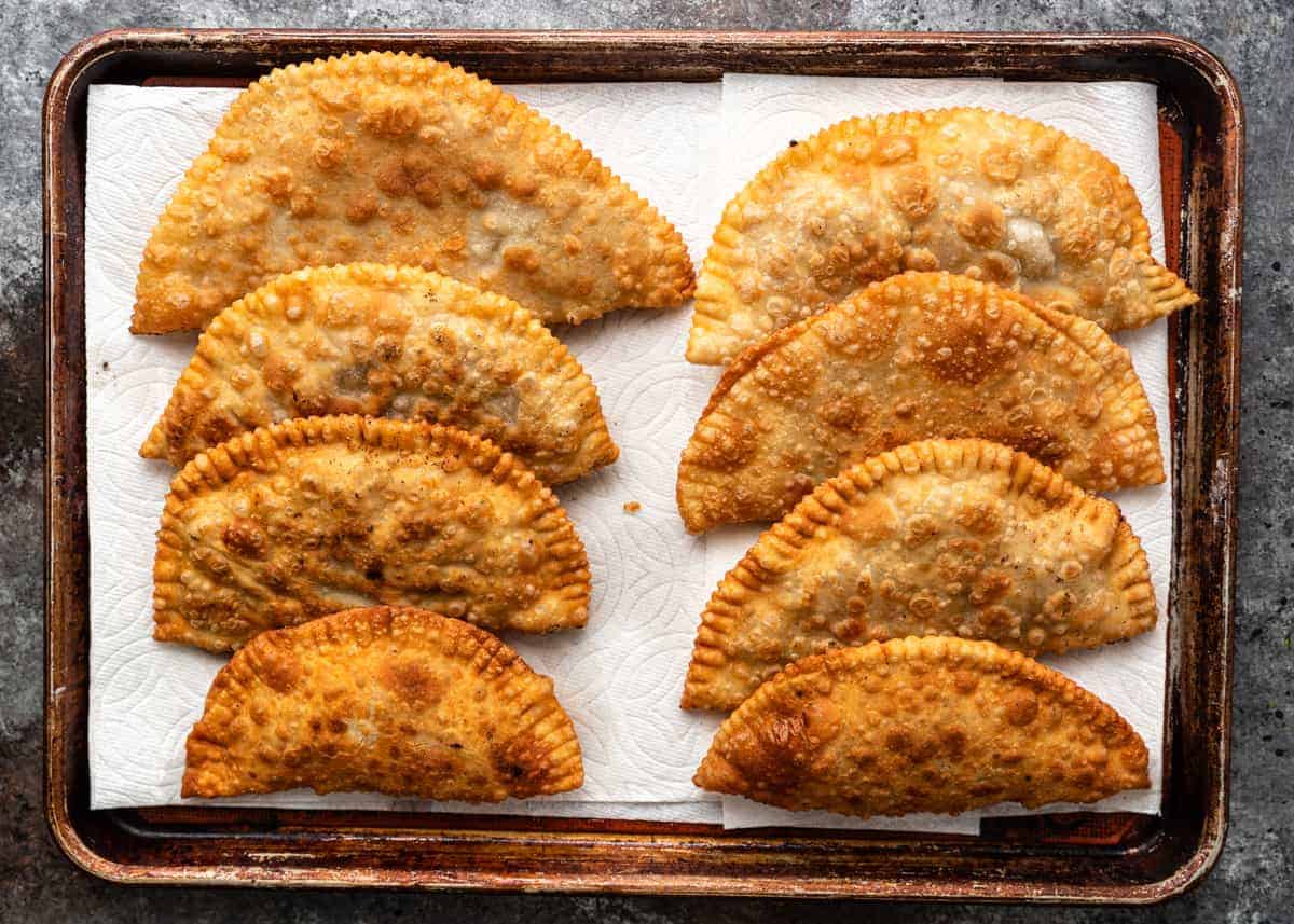 overhead: 8 savory fried turnovers on baking sheet