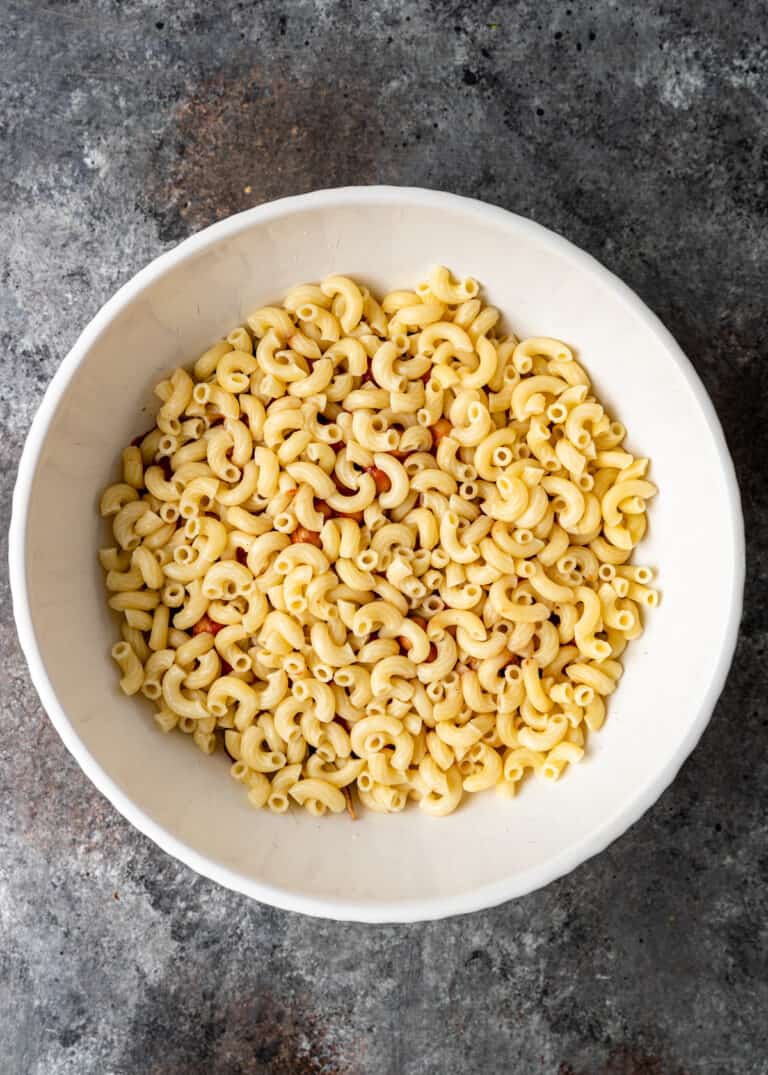 overhead: cooked elbow macaroni in white mixing bowl