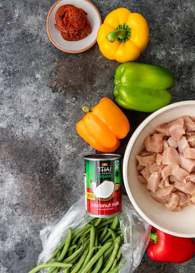 overhead: raw chicken breast and other ingredients for panang curry recipe