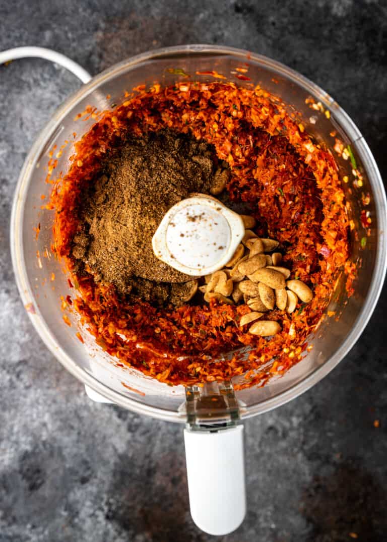 overhead: grinding peanuts and curry powder in bowl of food processor