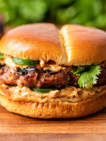 ground pork and beef burger with jalapenos and spicy peanut sauce on soft bun