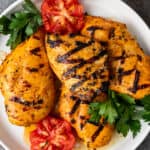 plate of grilled saffron chicken with tomatoes
