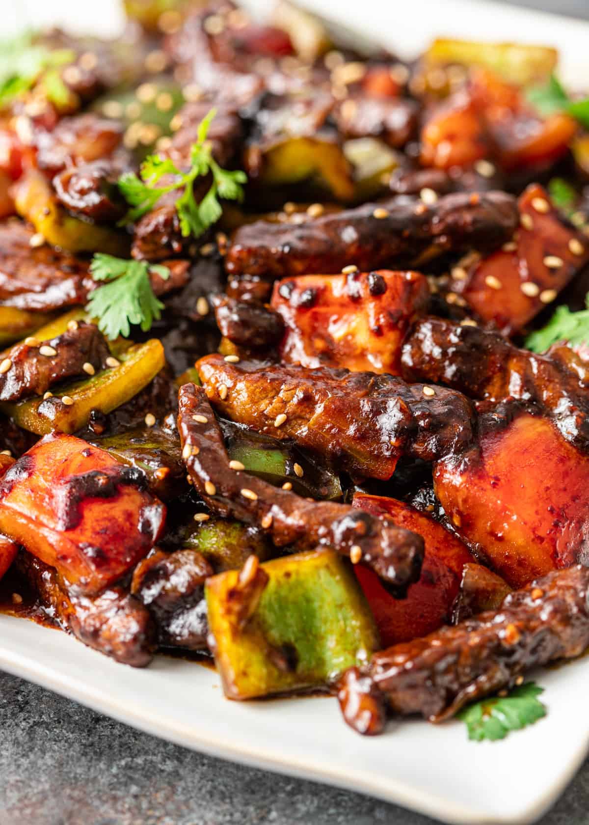 closeup: pepper steak stir fry with vegetables and sesame seeds in dark sauce