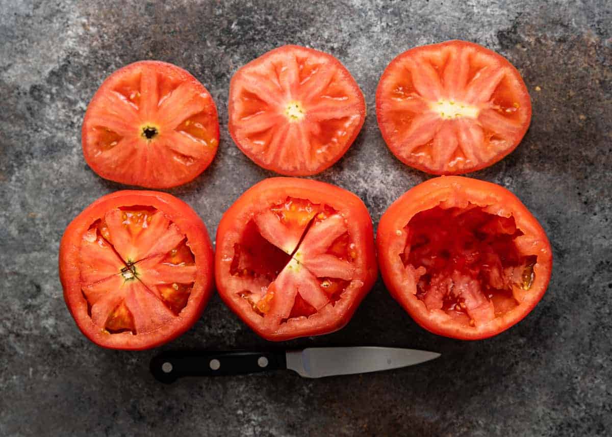 overhead: 3 large red tomatoes with insides removed for stuffing