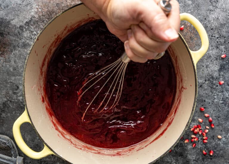 whisking pomegranate syrup in large pot for locum recipe