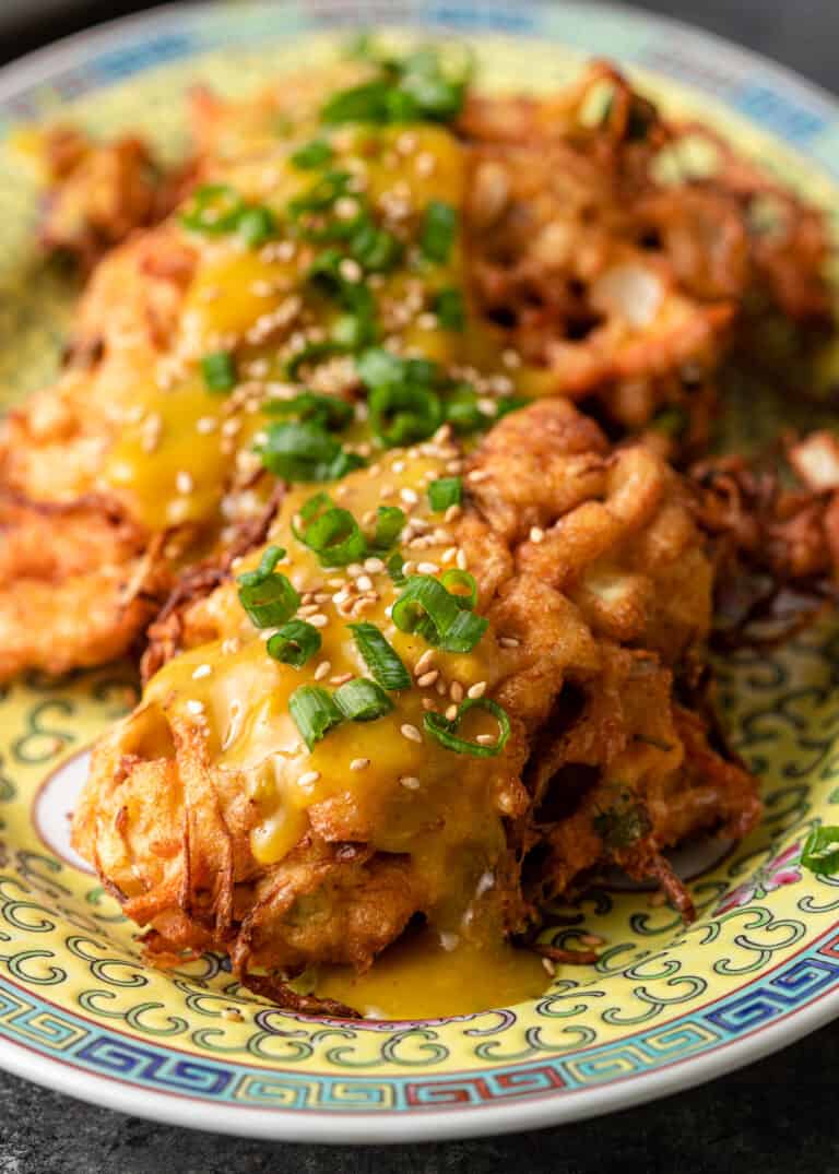 close up of egg foo young with scallion garnish on platter