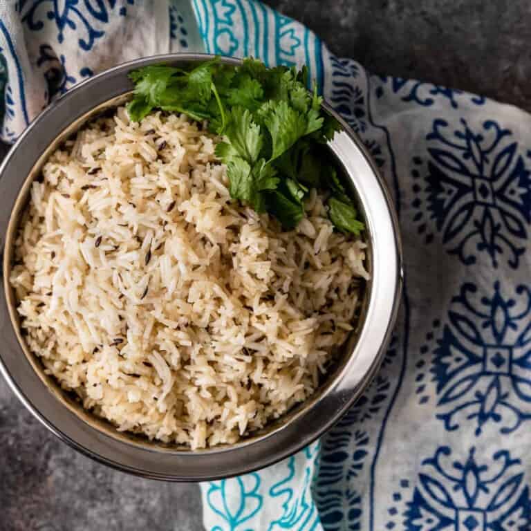overhead: bowl of jeera rice garnished with parsley