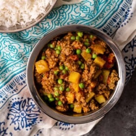 overhead: bowl of indian curry with ground beef and peas