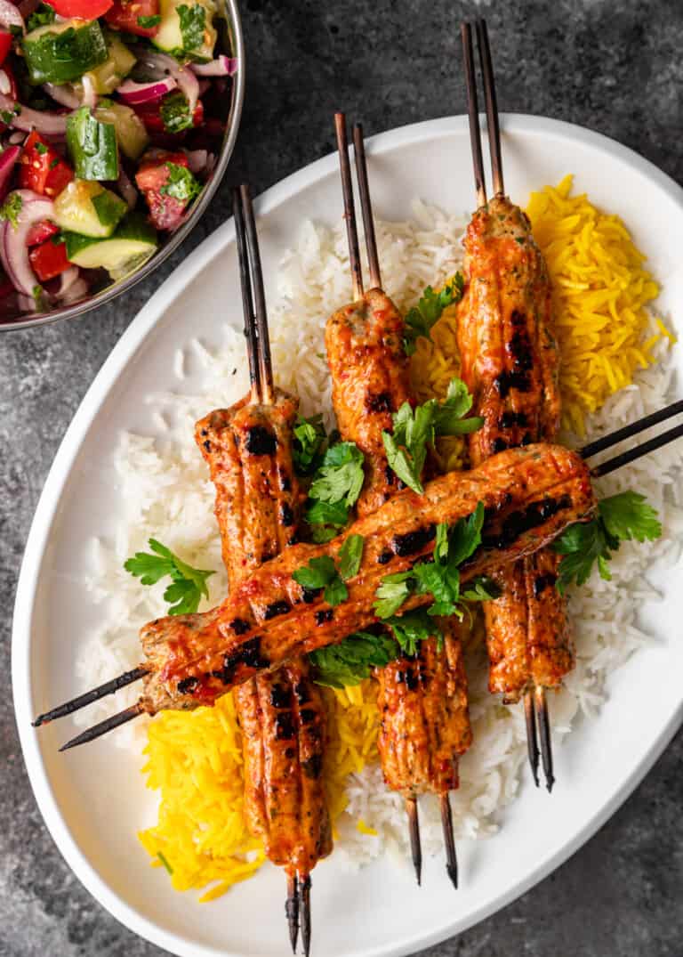 overhead: persian chicken skewers on platter of cooked rice
