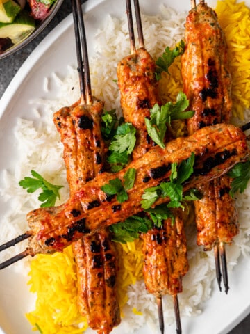 overhead: persian saffron chicken koobideh kabob on platter with white and saffron rice