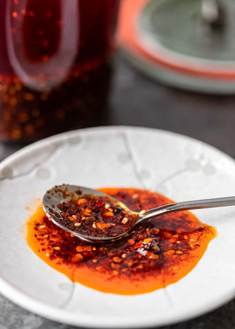 close up of crispy chili oil with spoon on white dish