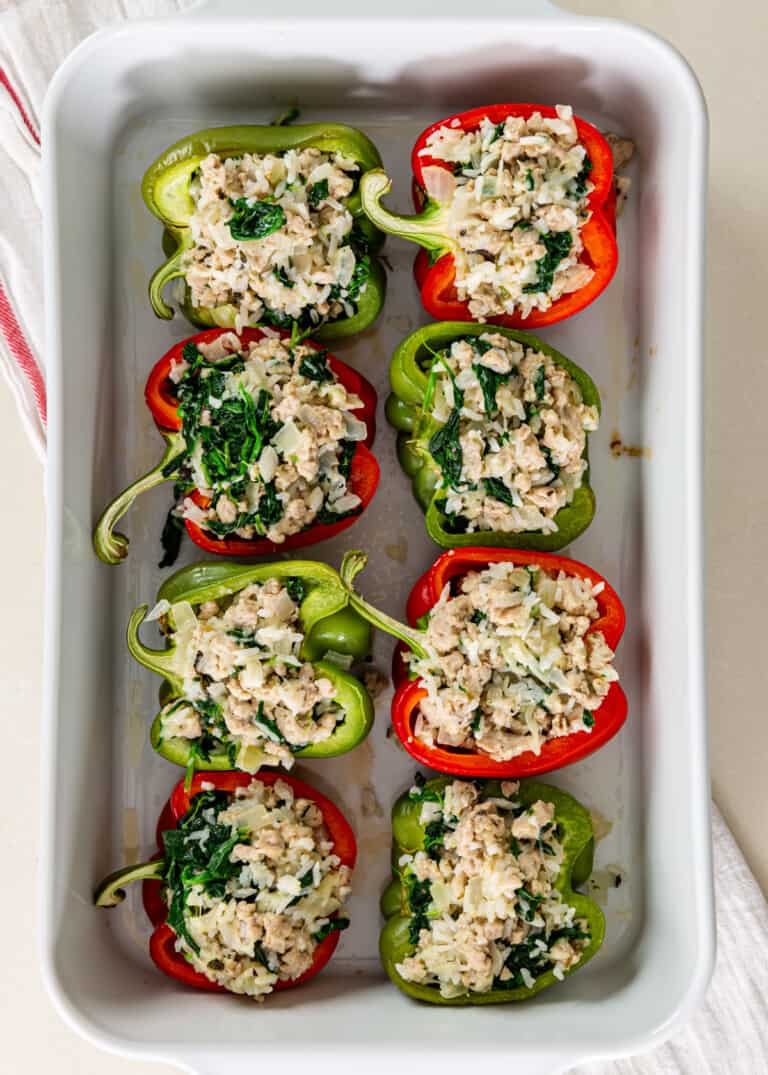 overhead: unbaked greek stuffed peppers with chicken filling