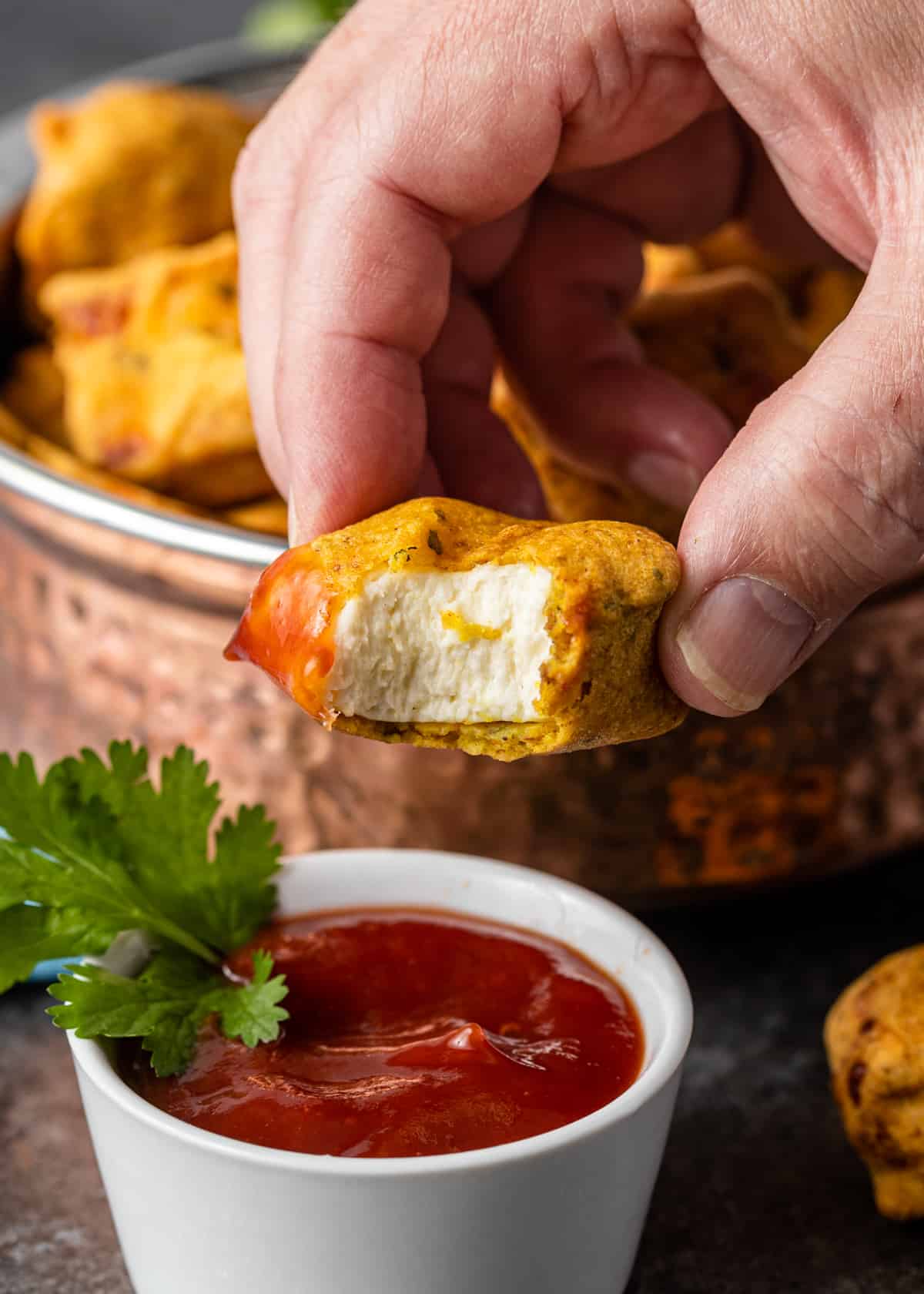 man's hand holding indian cheese fritter