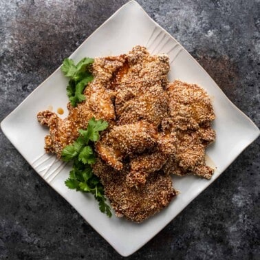 overhead: baked sesame chicken on square white plate