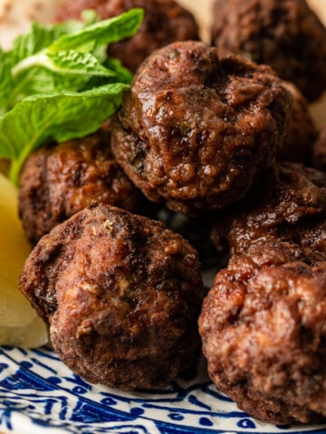 stack of Greek meatballs with lemon and mint sprig