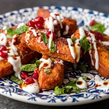 plate of halloumi fries with toppings yogurt, pomegranate seeds and mint