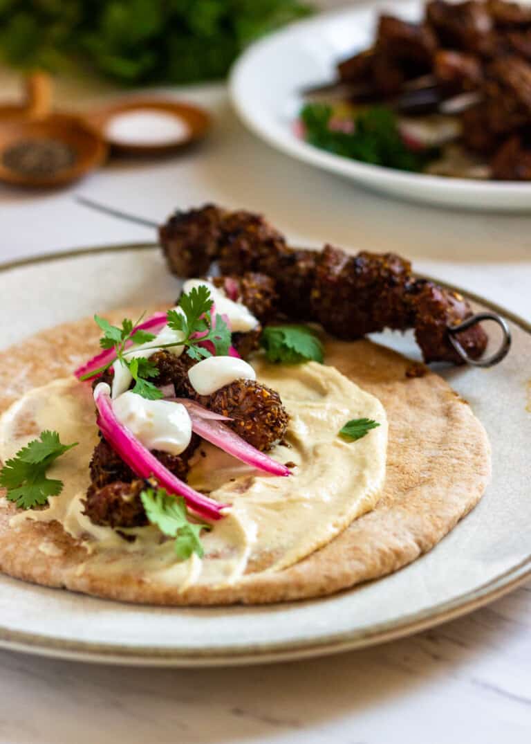 grilled lamb skewer beside tortilla with lamb