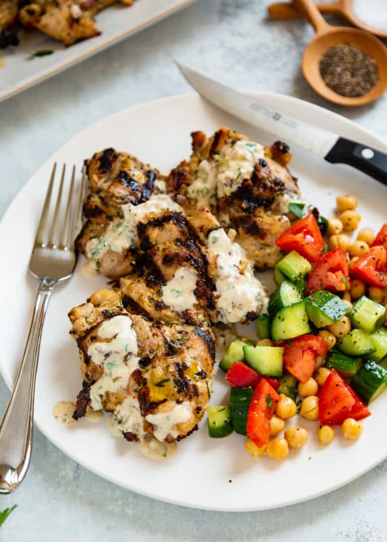 knife and fork on a plate with tahini chicken