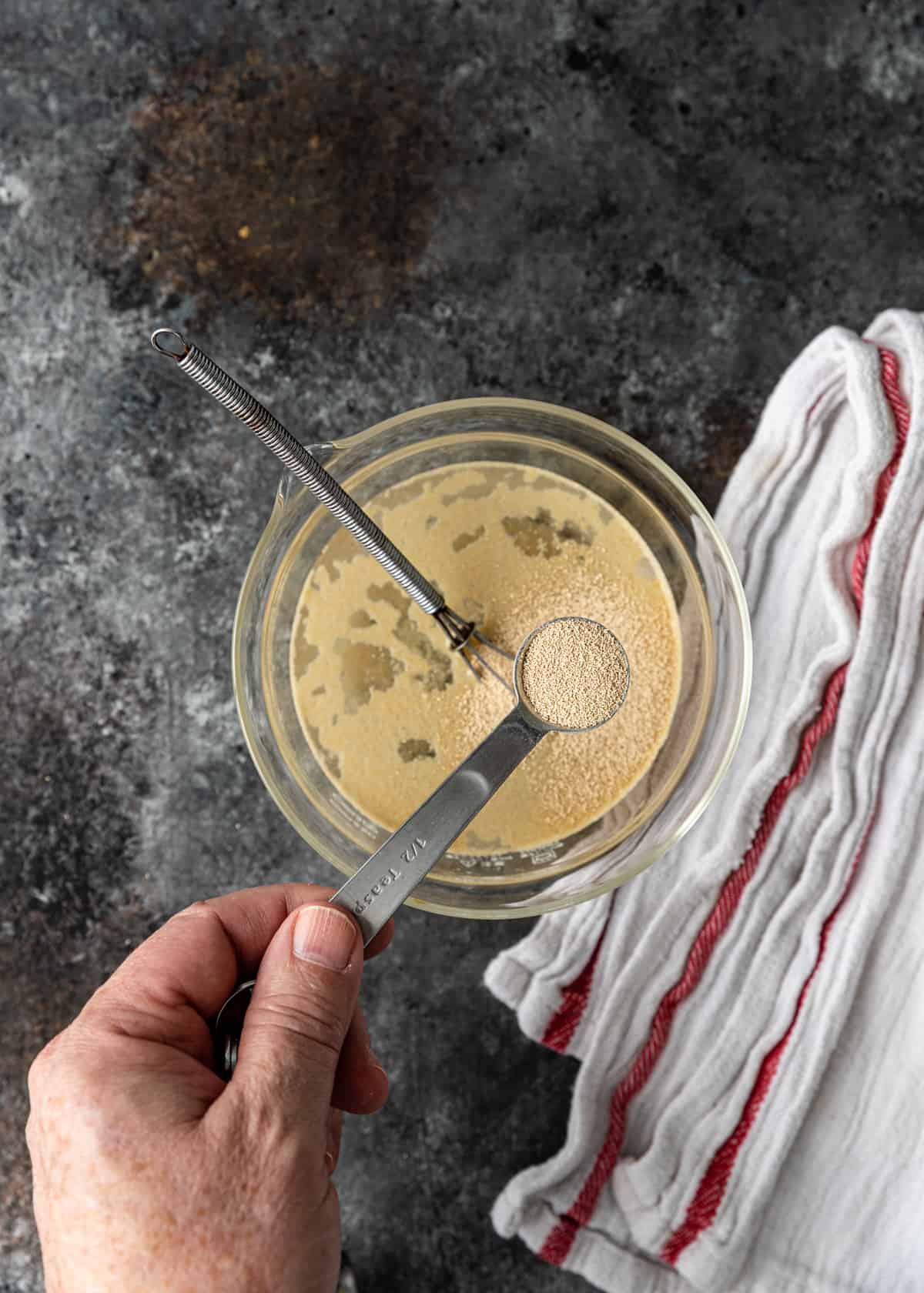 dry yeast in spoon going into bowl