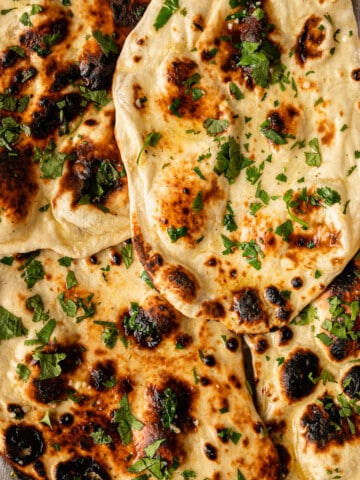close up of garlic naan with cilantro on tray