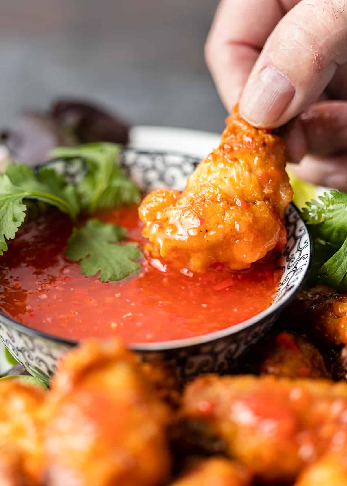 dipping chicken into Sweet Chili Sauce