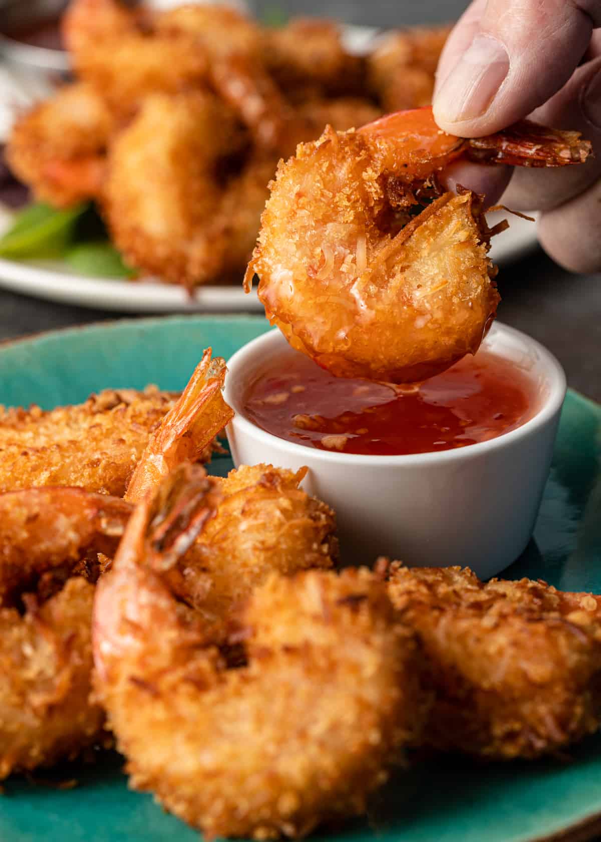 Coconut Shrimp being dipped in sauce