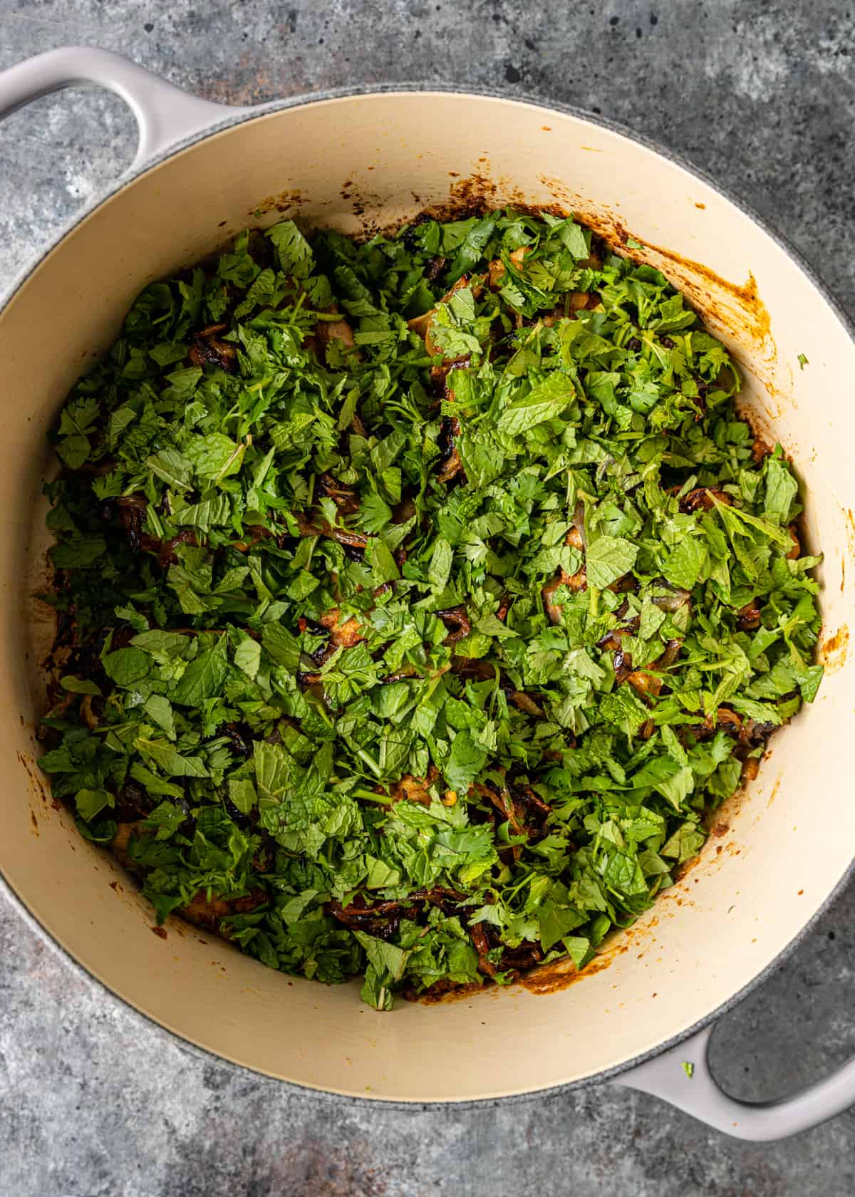 adding mint and cilantro to pan