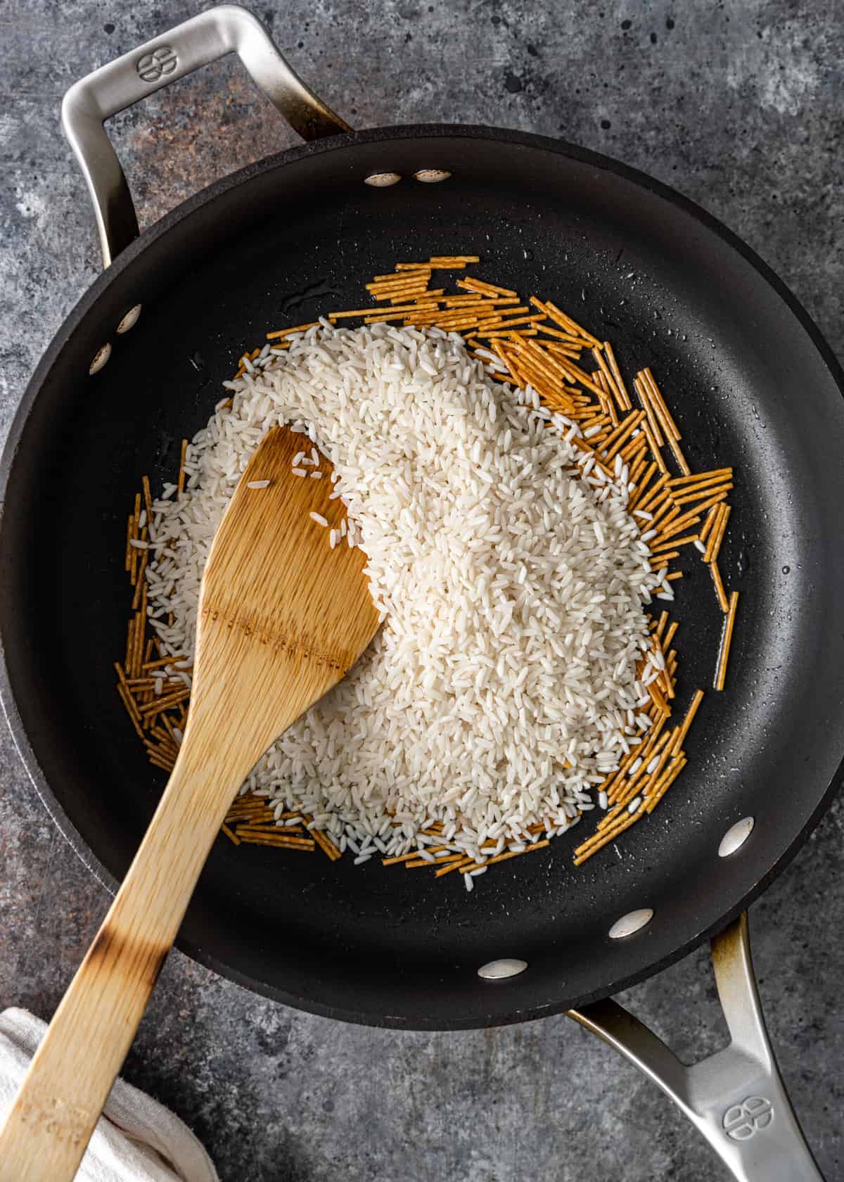 stirring Egyptian rice with vermicelli in a skillet