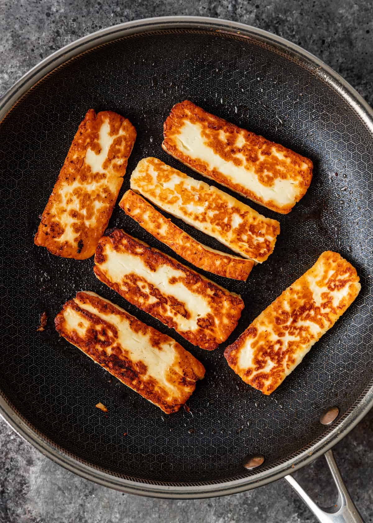 overhead: grilling halloumi cheese in a skillet