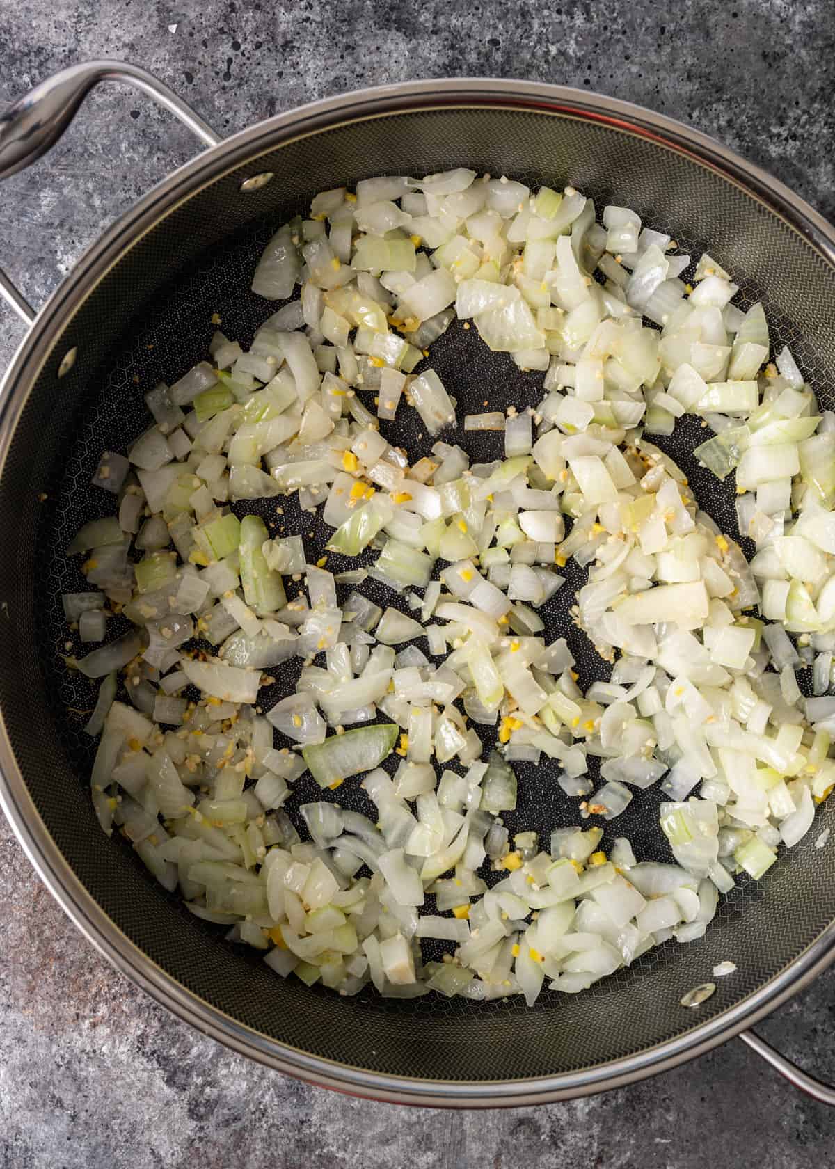 overhead: sautéing onion, garlic, and ginger in a pot