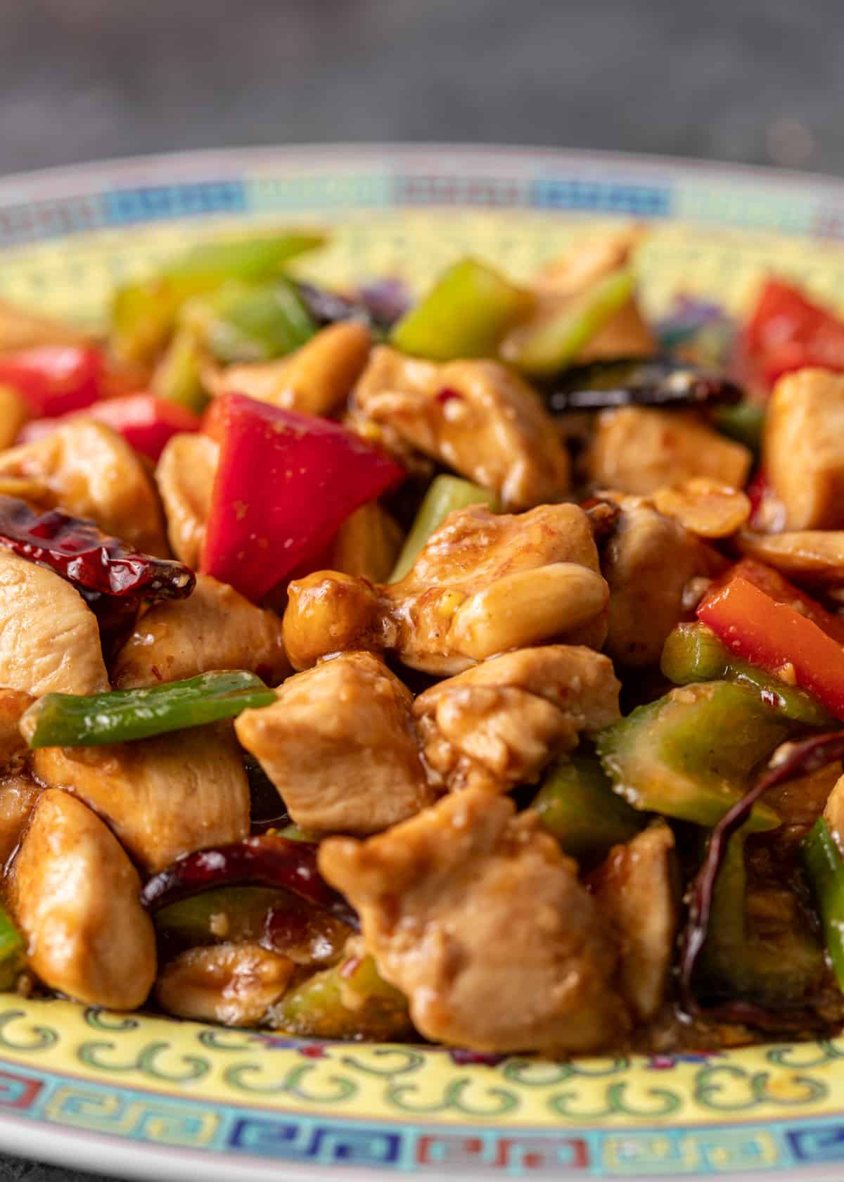 closeup: kung pao chicken recipe on a colorful ceramic plate with chicken and vegetables shown